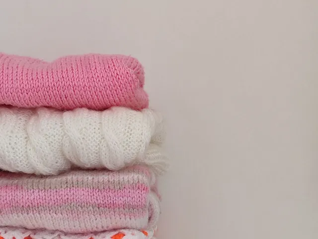 Colorful knitted sweaters folded on a shelf