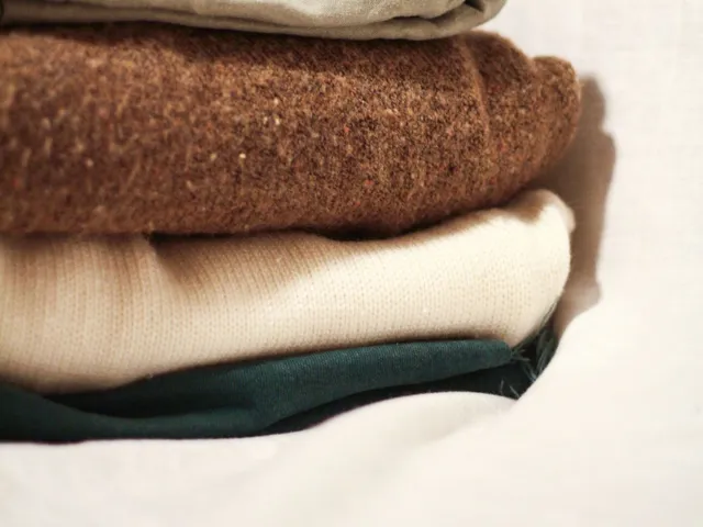 Folded knitted sweaters in soft natural light