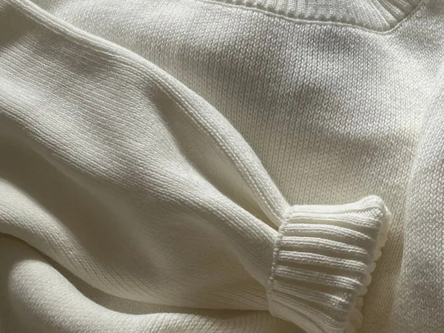 Close-up of white knitted sweater fabric texture