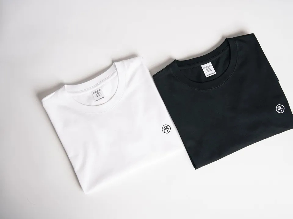 Stack of folded black and white knit t-shirts