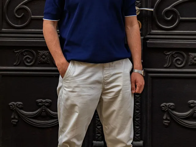 Man in a blue polo shirt by an ornate door