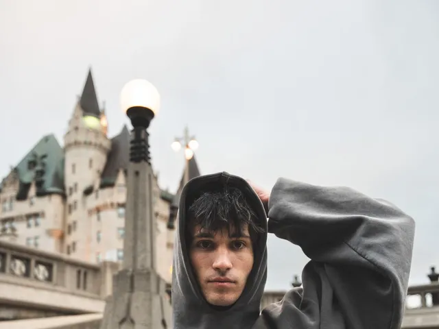 Fashionable man in a hoodie near a historic building