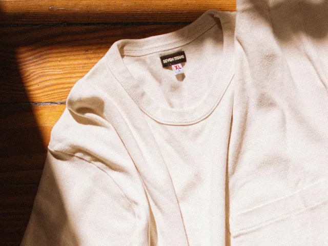White knit t-shirt flat lay with sunlight