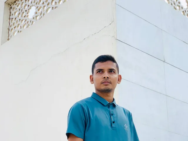 Man in a blue knitted polo shirt