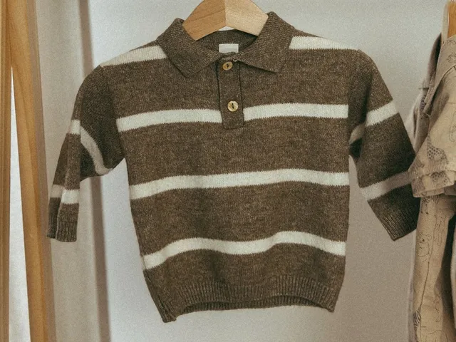 Striped children's sweater on a hanger