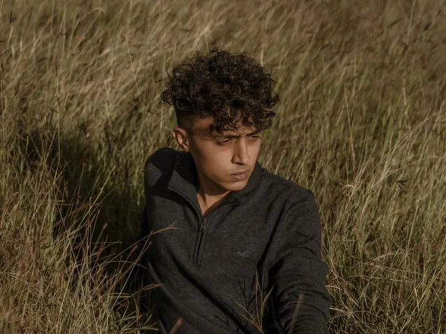 Model in a grey zipper sweater sitting in grass