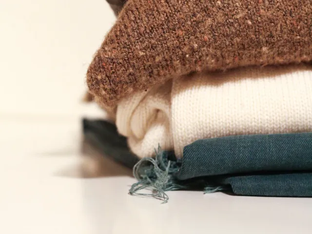 Stack of folded sweaters on a light background